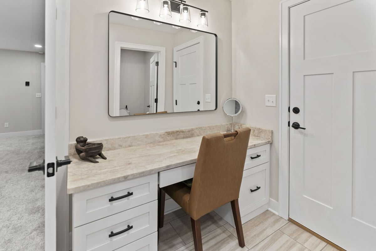 Bathroom makeup vanity in Stilwell, KS with custom cabinetry, quartz countertop, mirror, and task lighting.