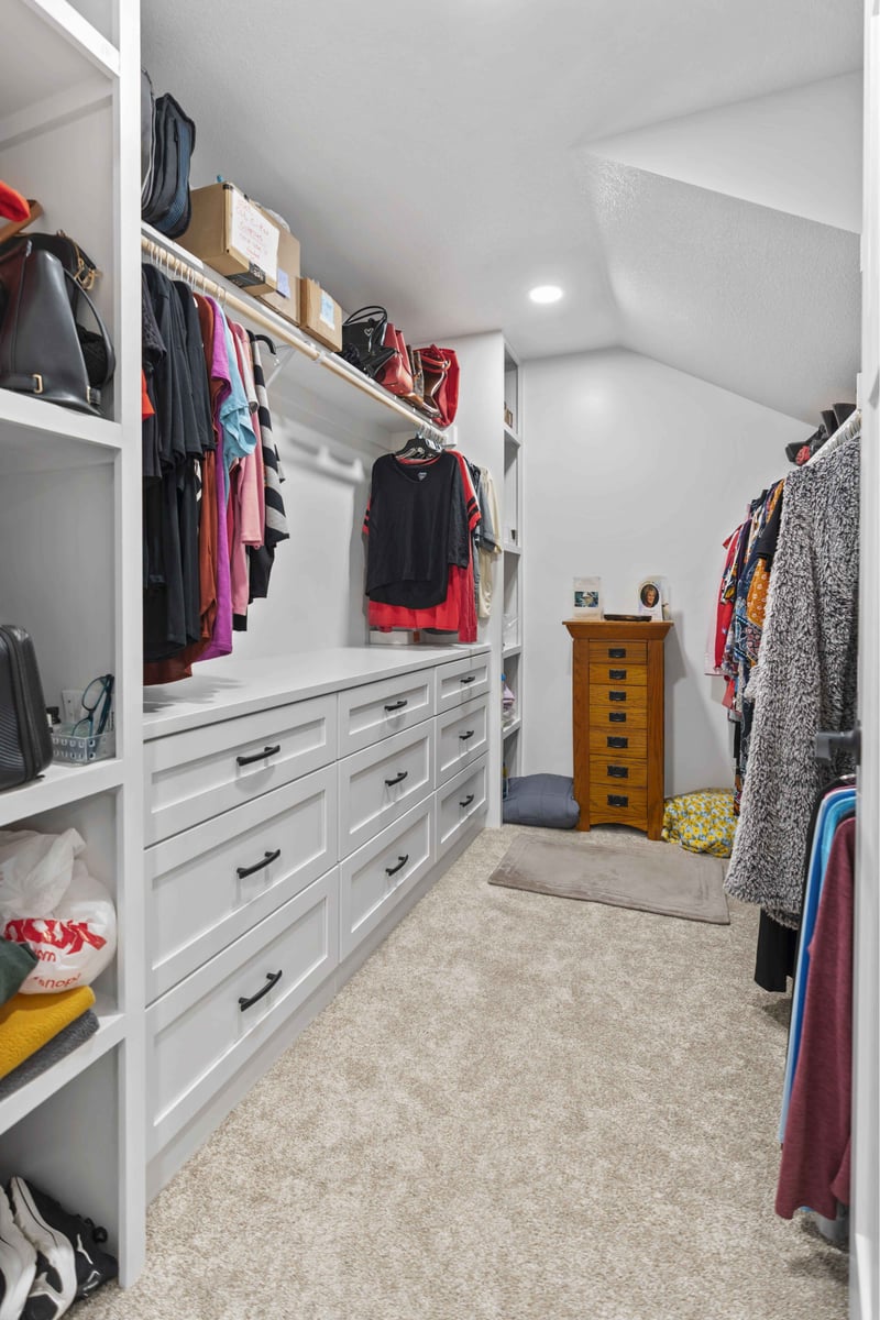 Custom walk-in closet remodel in Stilwell, KS with built-in drawers, shelving, and hanging storage.