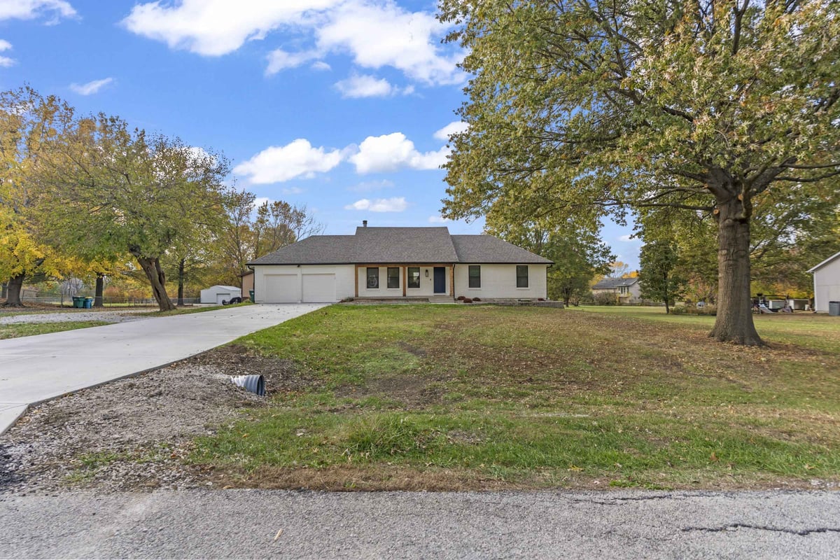 Exterior of remodeled home in Stilwell, KS with new driveway, updated landscaping, and refreshed front elevation.