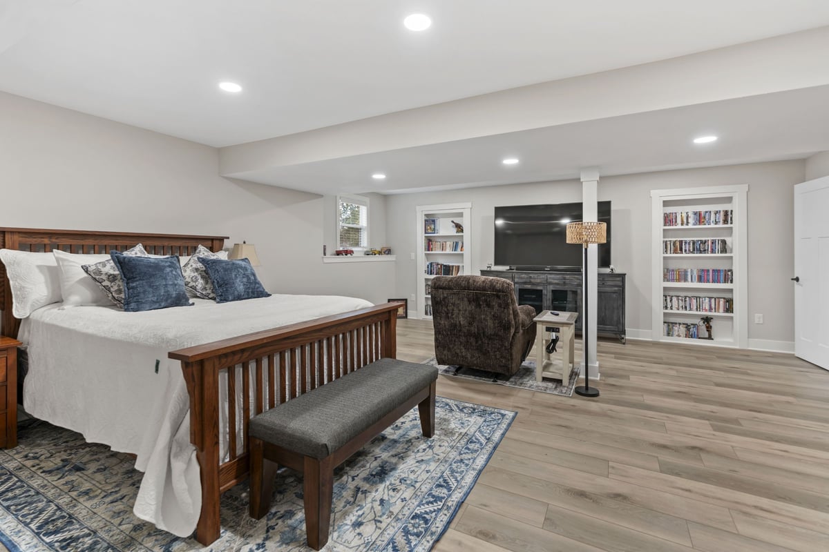 Finished basement bedroom in Stilwell, KS with new flooring, recessed lighting, and built-in shelving.