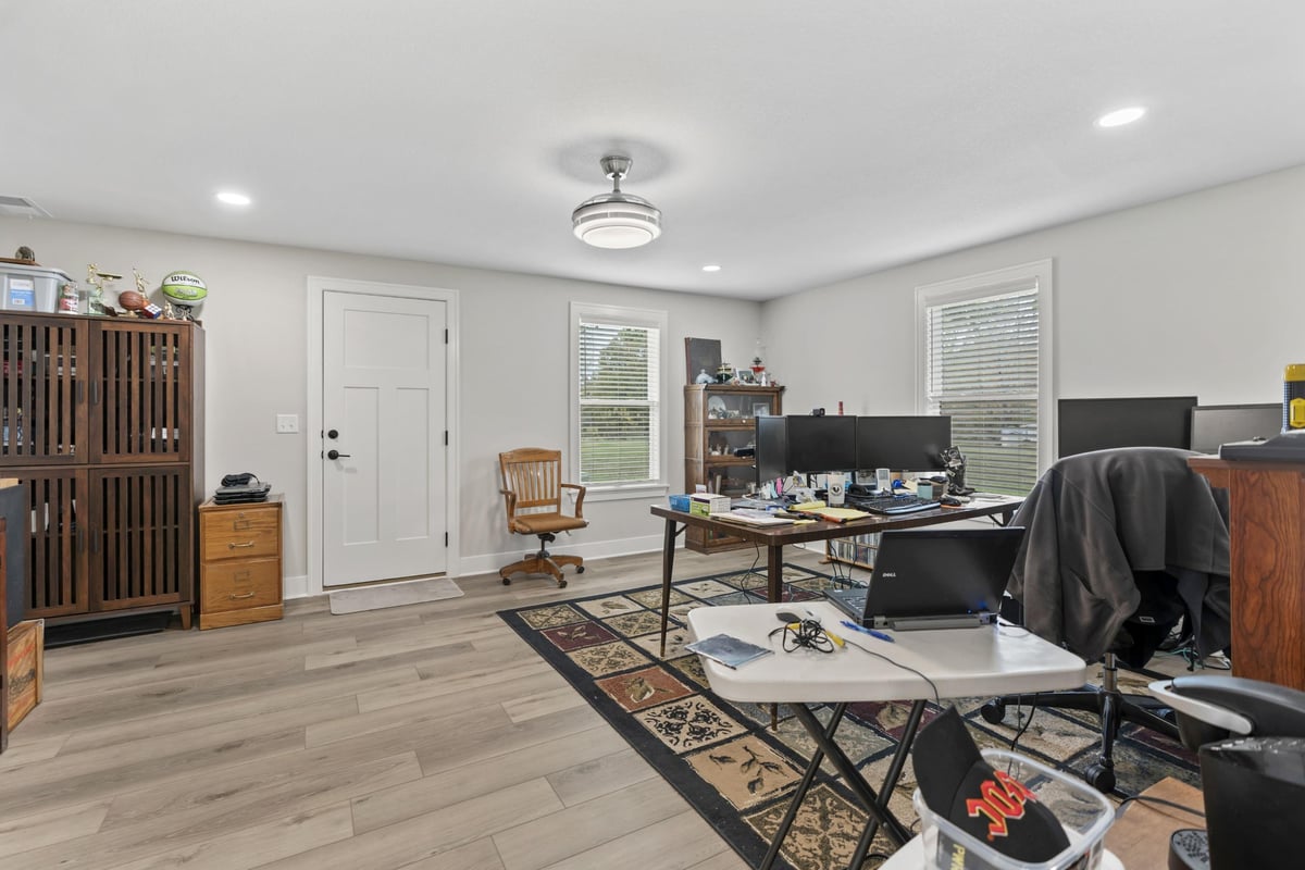 Home office remodel in Stilwell, KS with new flooring, updated lighting, and space for multiple workstations.