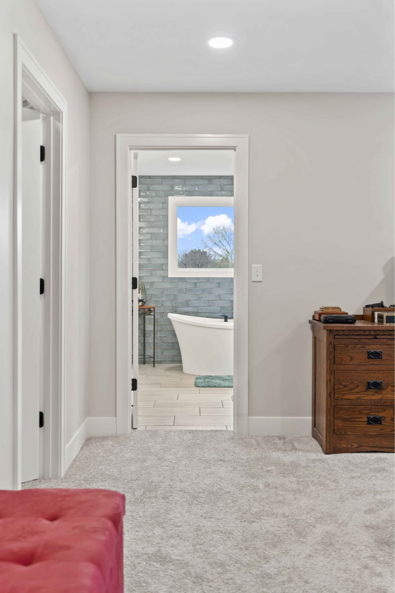 Remodeled bedroom in Stilwell, KS with new carpet, ceiling fan, and updated window trim.