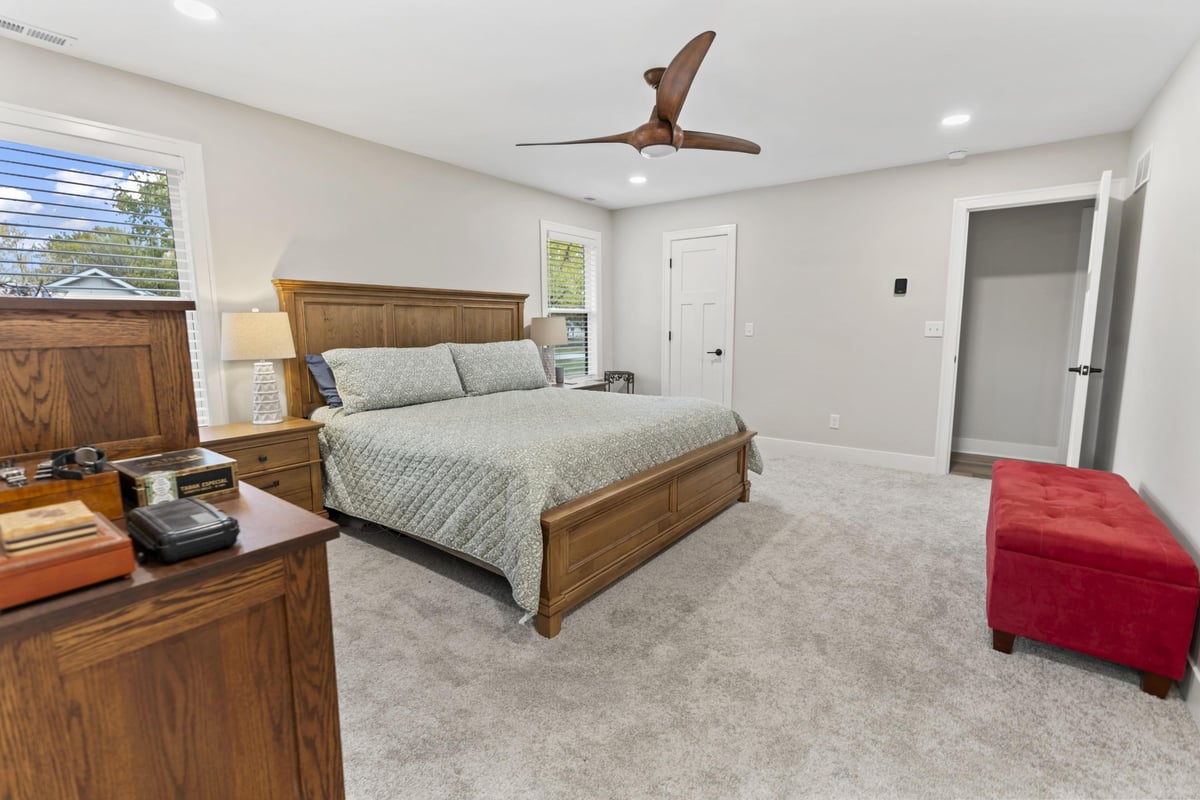 Spacious primary bedroom remodel in Stilwell, KS with new carpet, ceiling fan, and neutral finishes.