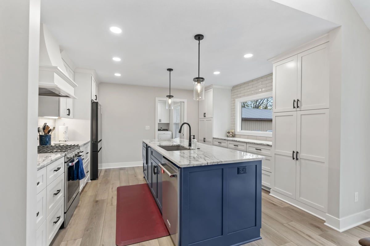 Stilwell, KS kitchen remodel showcasing a blue island, quartz countertops, custom cabinetry, and modern pendant lighting.