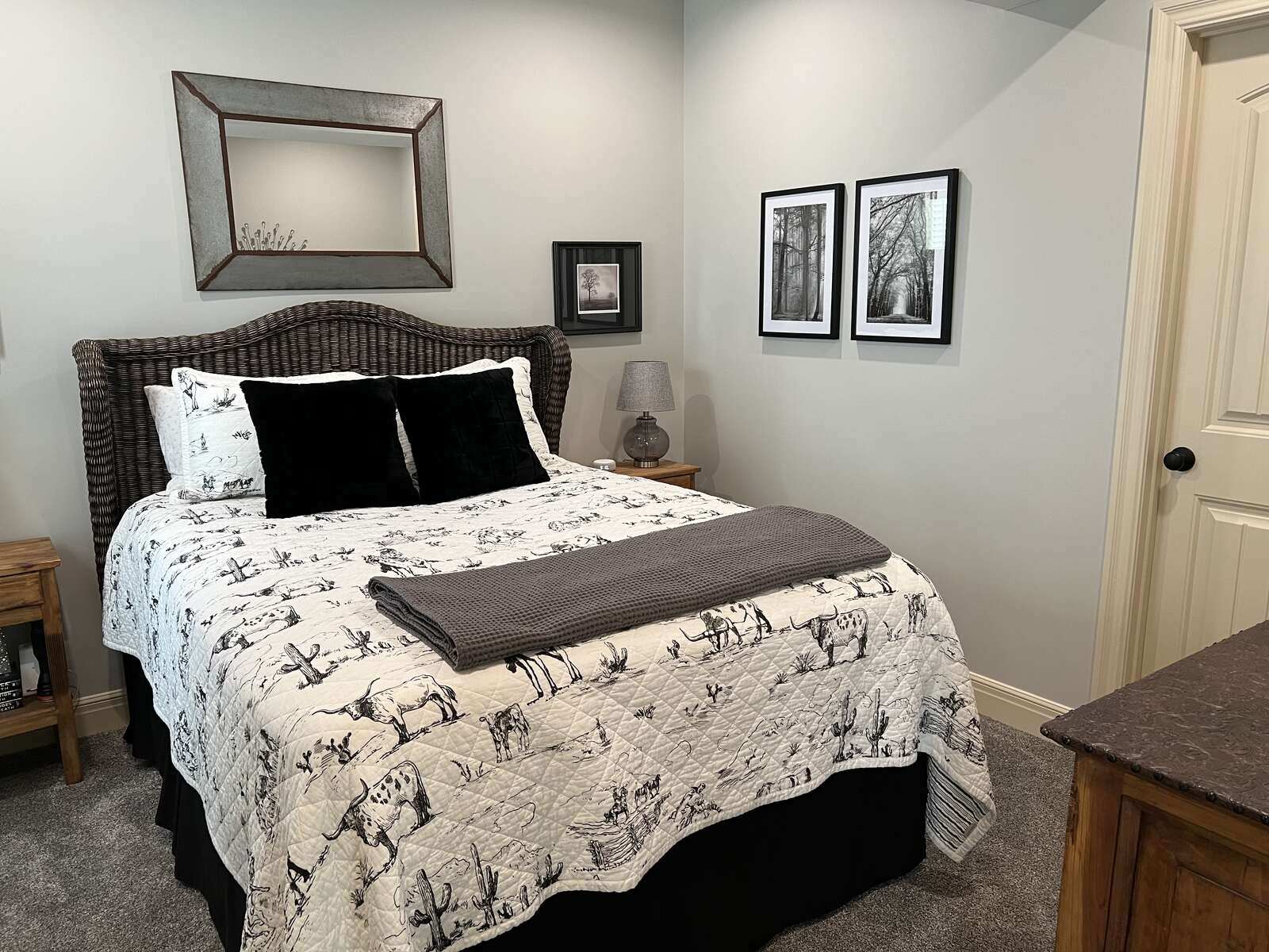 Cozy basement guest bedroom remodel with a rustic bed frame and neutral decor by Top Shelf Home Builders in Metro Kansas City