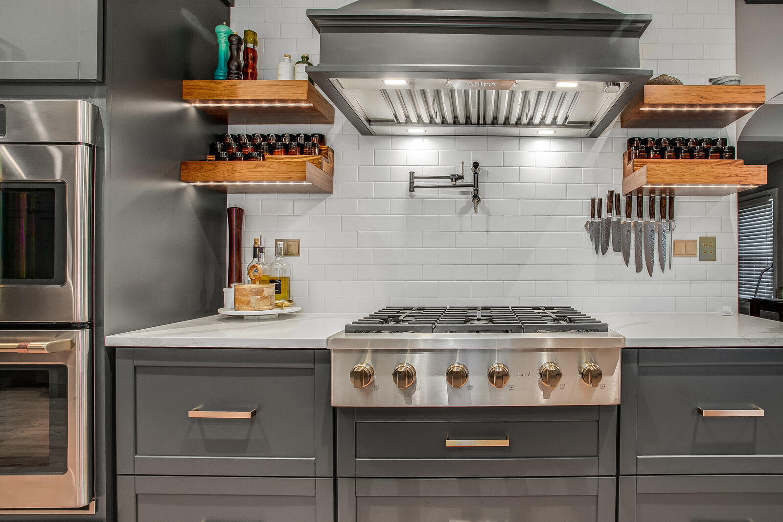 Luxury kitchen with a high-end gas range, custom knife storage, and open spice shelves, part of a remodel by Top Shelf Home Builders in Metro Kansas City