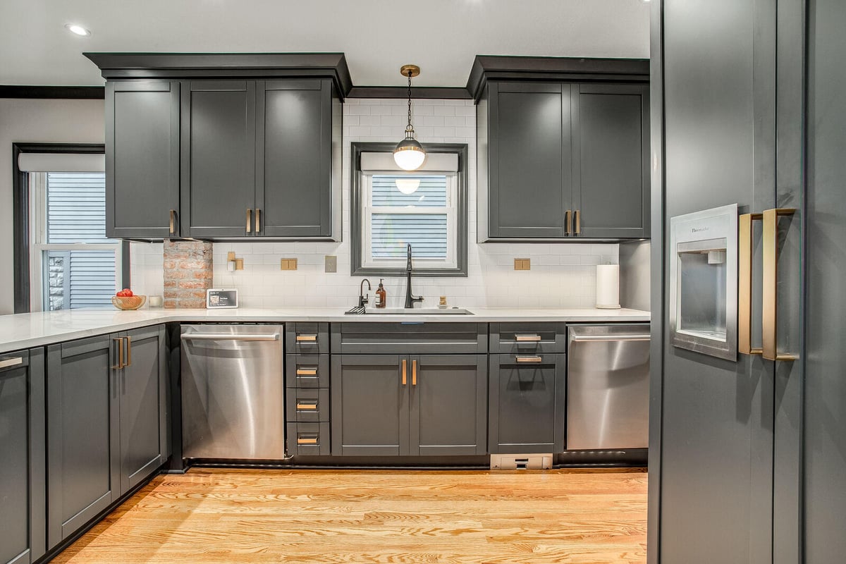 Contemporary kitchen remodel with custom black cabinetry, a sleek island, and gold-accented hardware in Waldo, MO