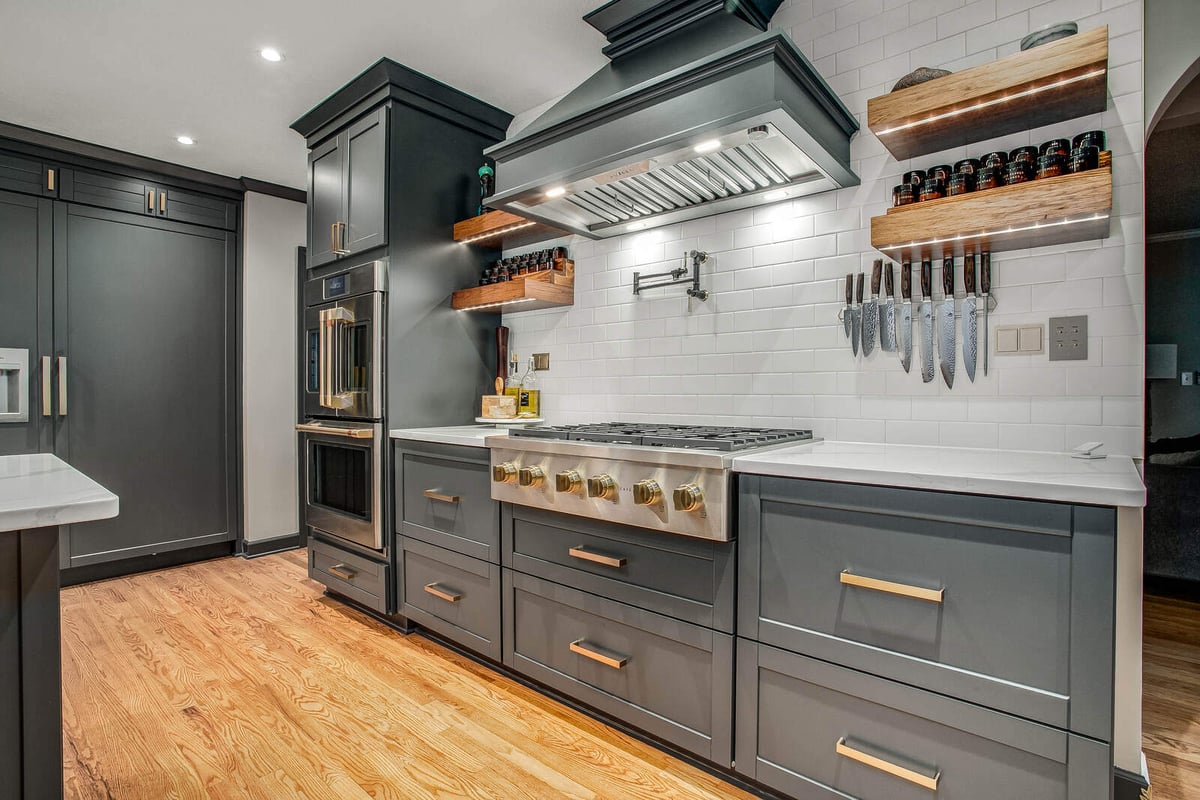 Custom kitchen remodel in Waldo, MO with black cabinetry, a professional-grade stove, and open shelving by Top Shelf Home Builders