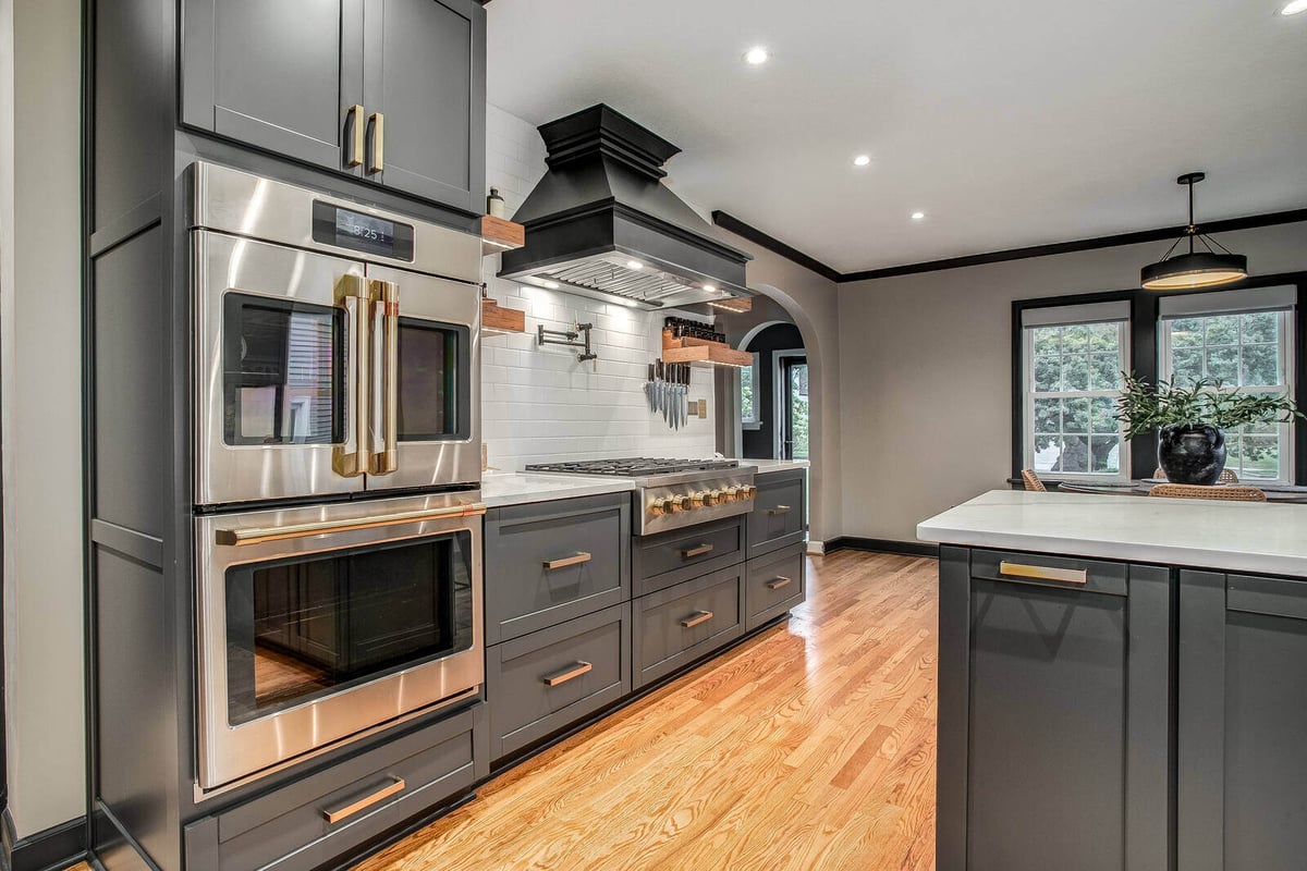 High-end kitchen renovation with a sleek black and gold aesthetic, complete with top-tier appliances in Waldo, MO
