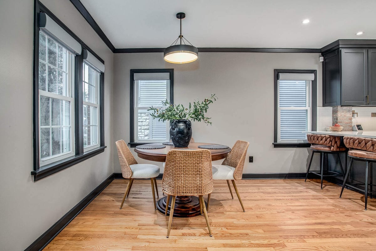 Stylish dining area with a pendant light, woven chairs, and black-trimmed windows in a Waldo kitchen remodel