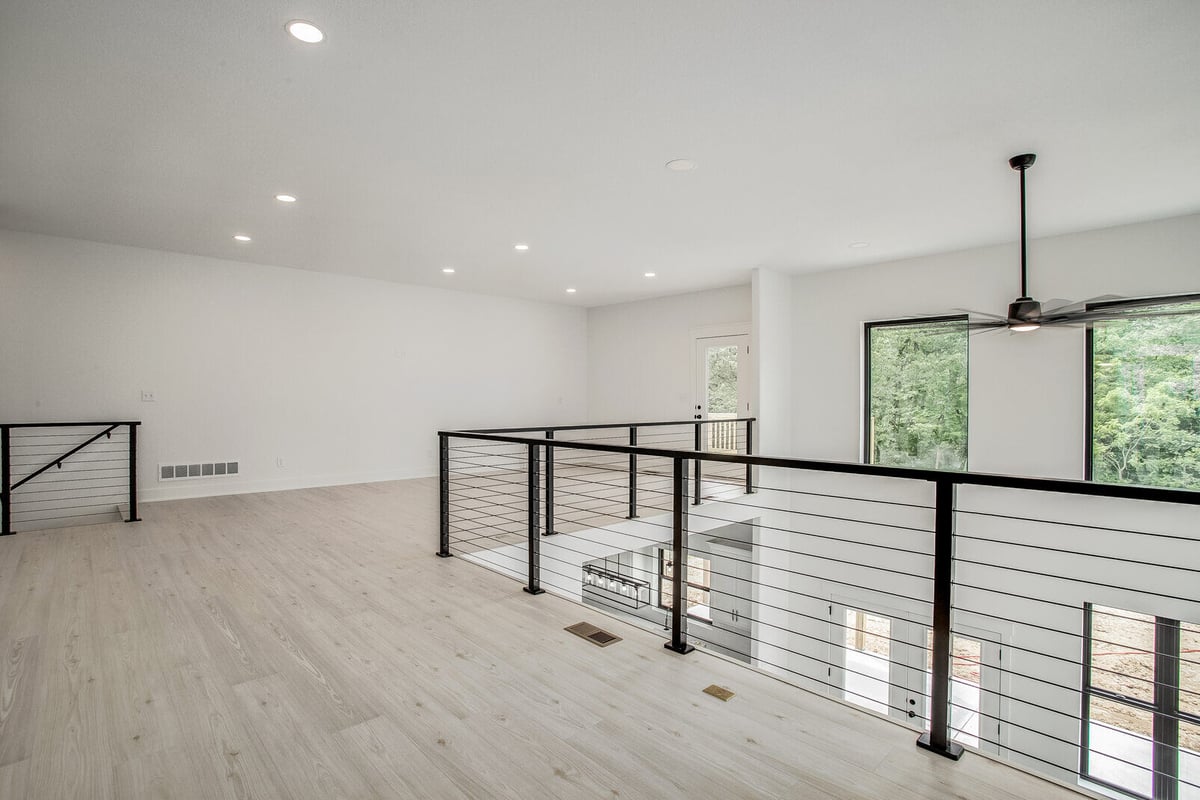Bright upper-level space with open railing and views of the lower living area in a Metro Kansas City home remodel