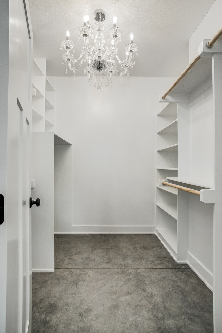 Luxurious walk-in closet with built-in shelving and a crystal chandelier