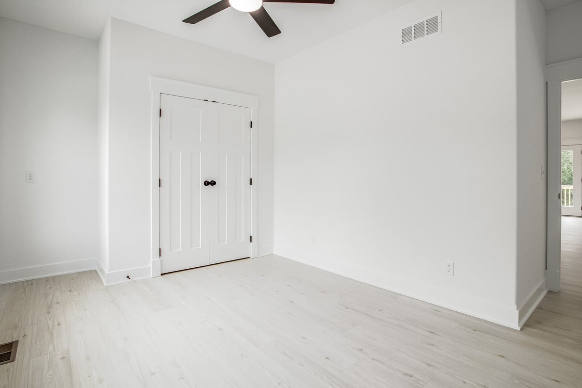 Modern bedroom featuring a closet with white panel doors and black handles