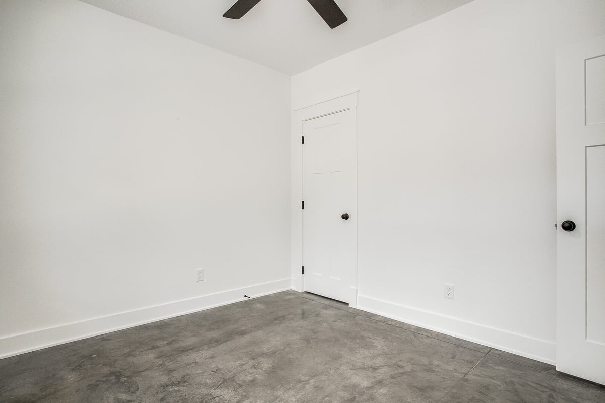 Modern minimalist bedroom with polished concrete floors in a whole home remodel by Top Shelf Home Builders in Metro Kansas City