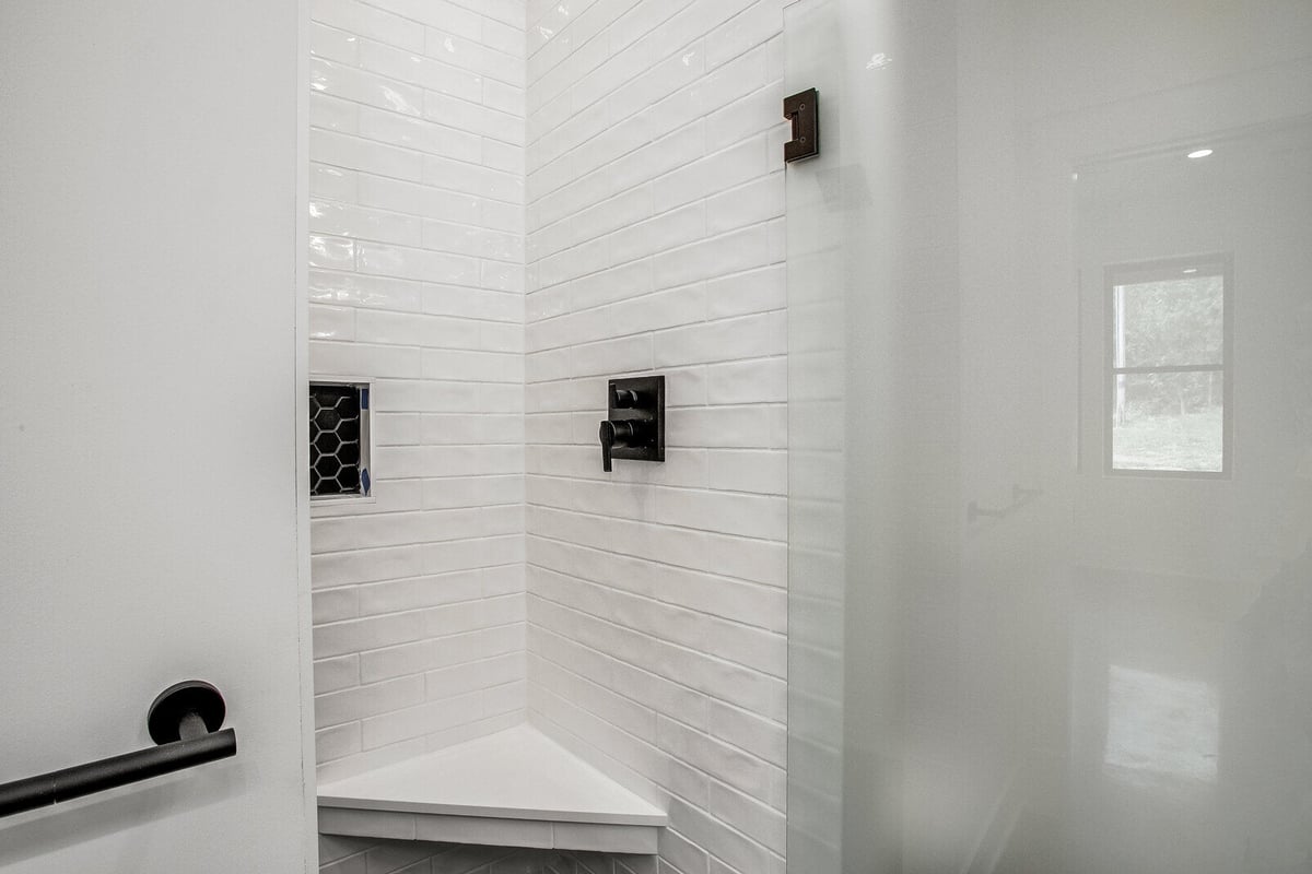 Modern walk-in shower with white subway tiles and black fixtures