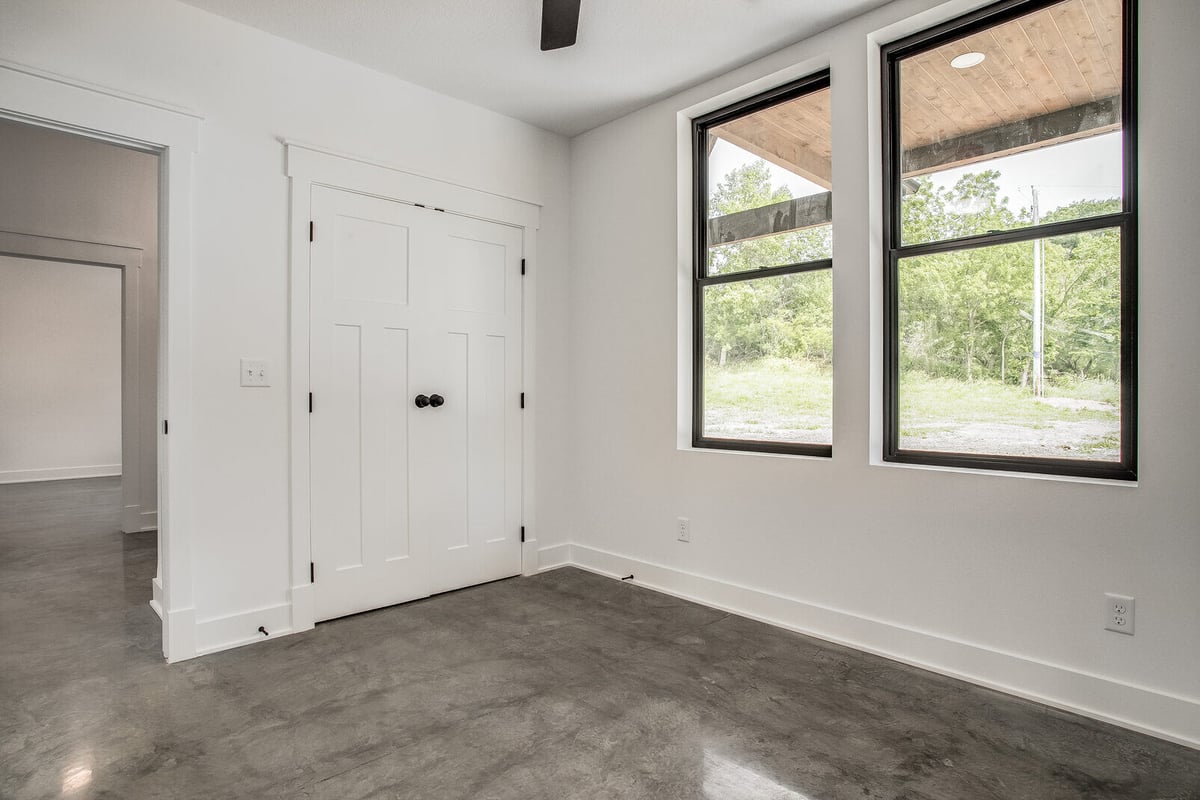 Remodeled bedroom featuring a large window and a double-door closet, part of a whole home renovation by Top Shelf Home Builders in Metro Kansas City.jpg