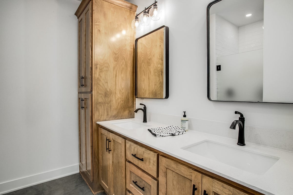 Rustic-modern bathroom featuring wooden cabinetry and black fixtures