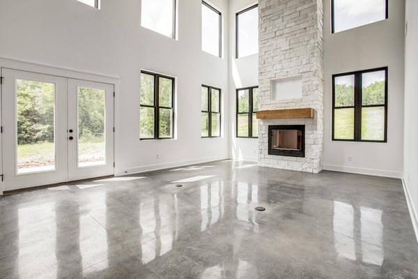 Spacious living area with a towering stone fireplace and expansive windows, part of a whole home remodel by Top Shelf Home Builders in Metro Kansas City.jpg