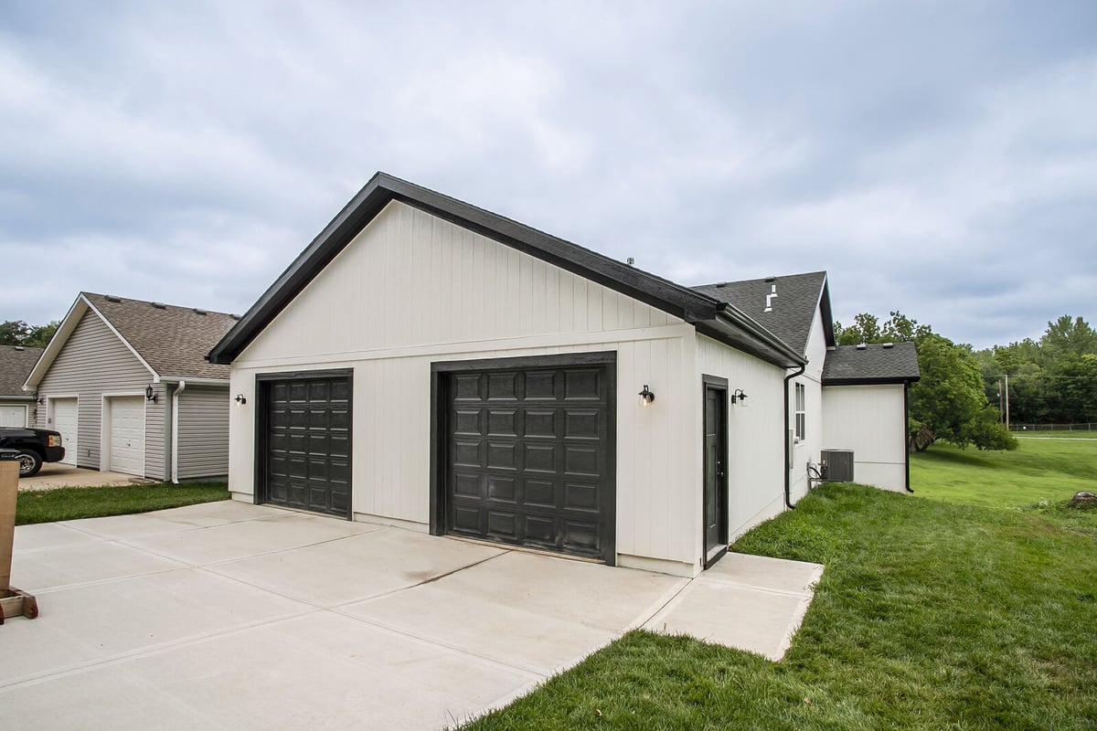 Front angle of a Kansas City home remodel featuring a large covered porch, completed by Top Shelf Home Builders