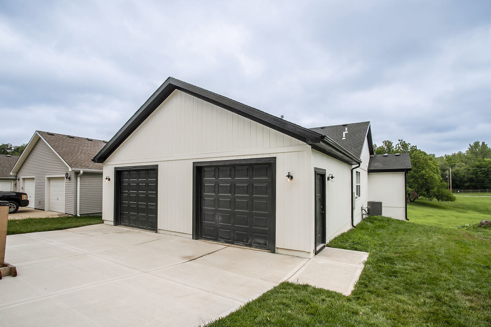 Front angle of a Kansas City home remodel featuring a large covered porch, completed by Top Shelf Home Builders