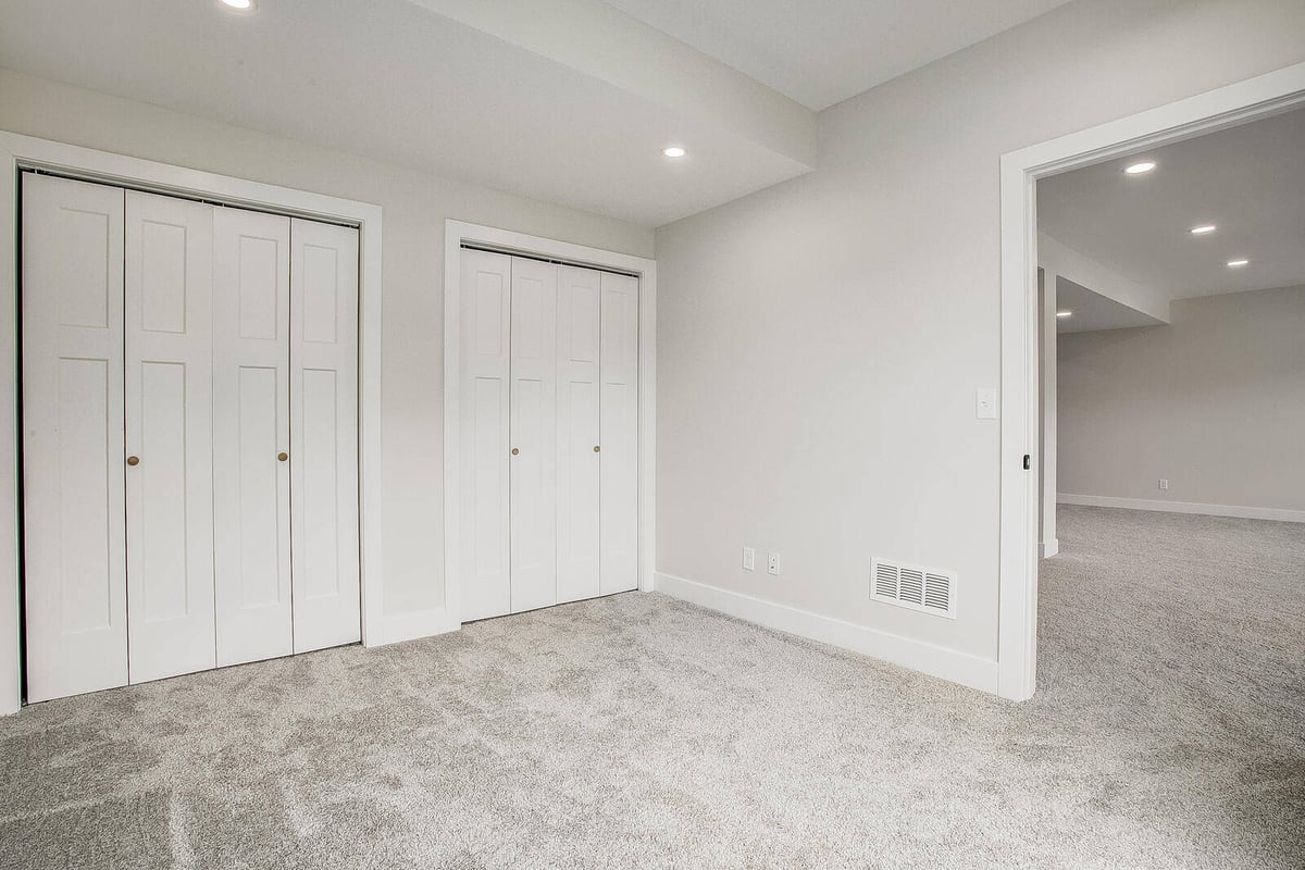 Kansas City whole home remodel featuring a newly designed bedroom with double-door closets by Top Shelf Home Builders