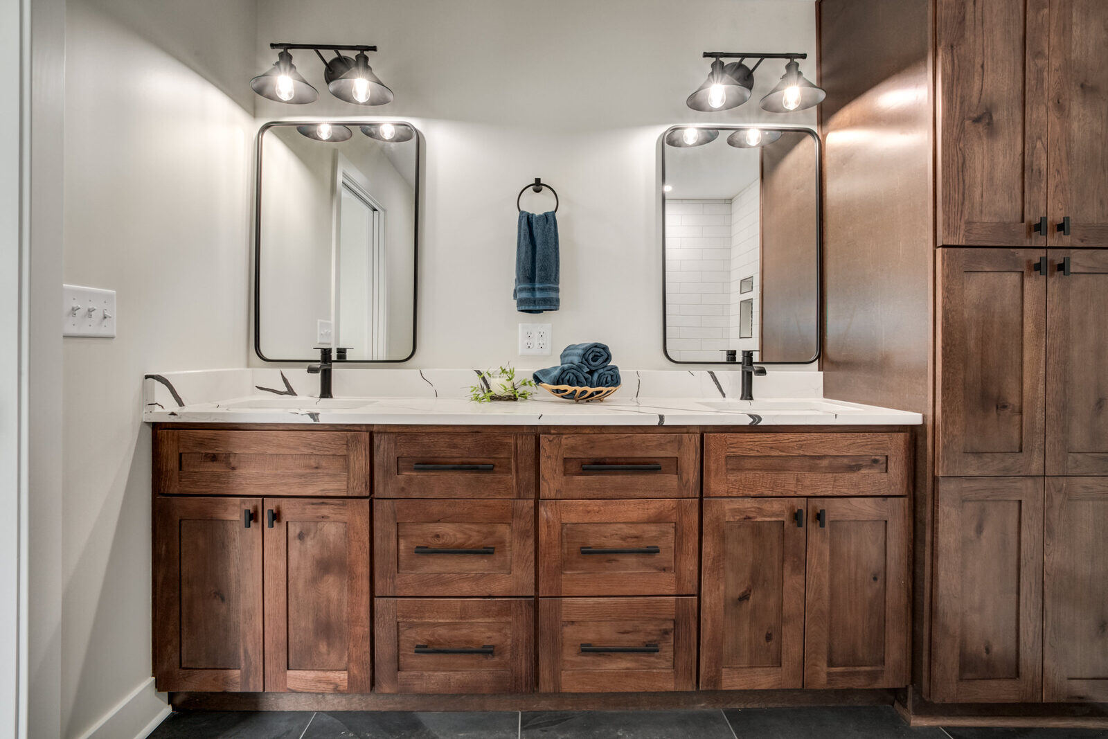 Modern bathroom with a dual vanity, black fixtures, and wooden cabinetry, part of a Metro Kansas City home remodel by Top Shelf Home Builders