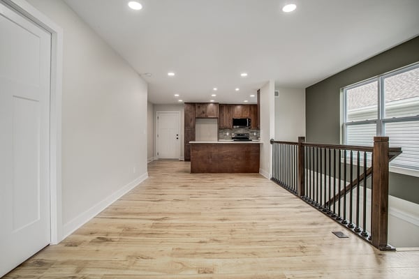 Open-concept living space leading into a modern kitchen with wooden cabinetry in a Burton home remodel