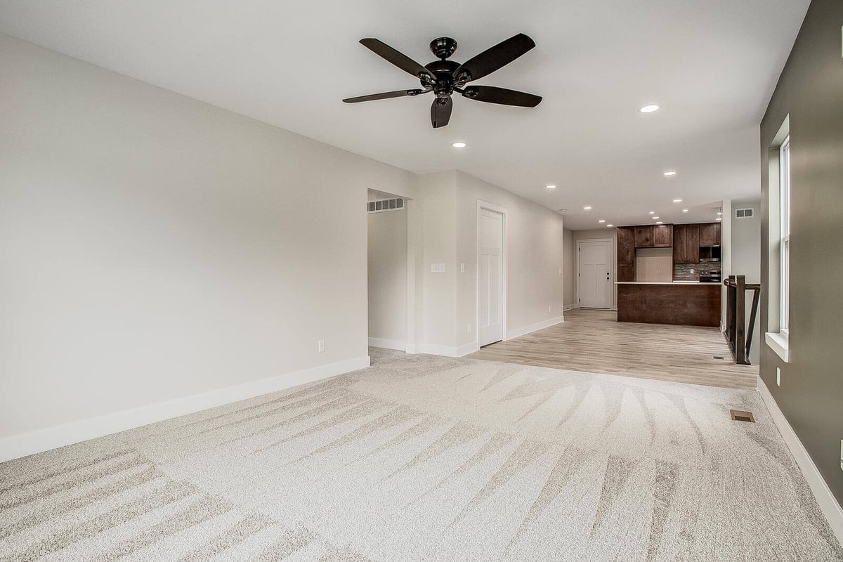 Renovated Kansas City living space with plush carpet, a ceiling fan, and recessed lighting, completed by Top Shelf Home Builders