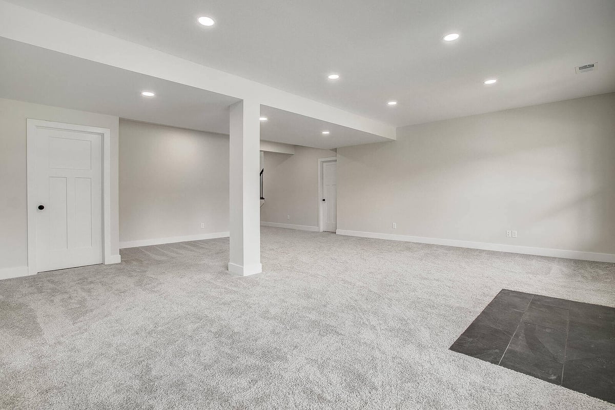 Spacious carpeted basement renovation in Kansas City, designed by Top Shelf Home Builders