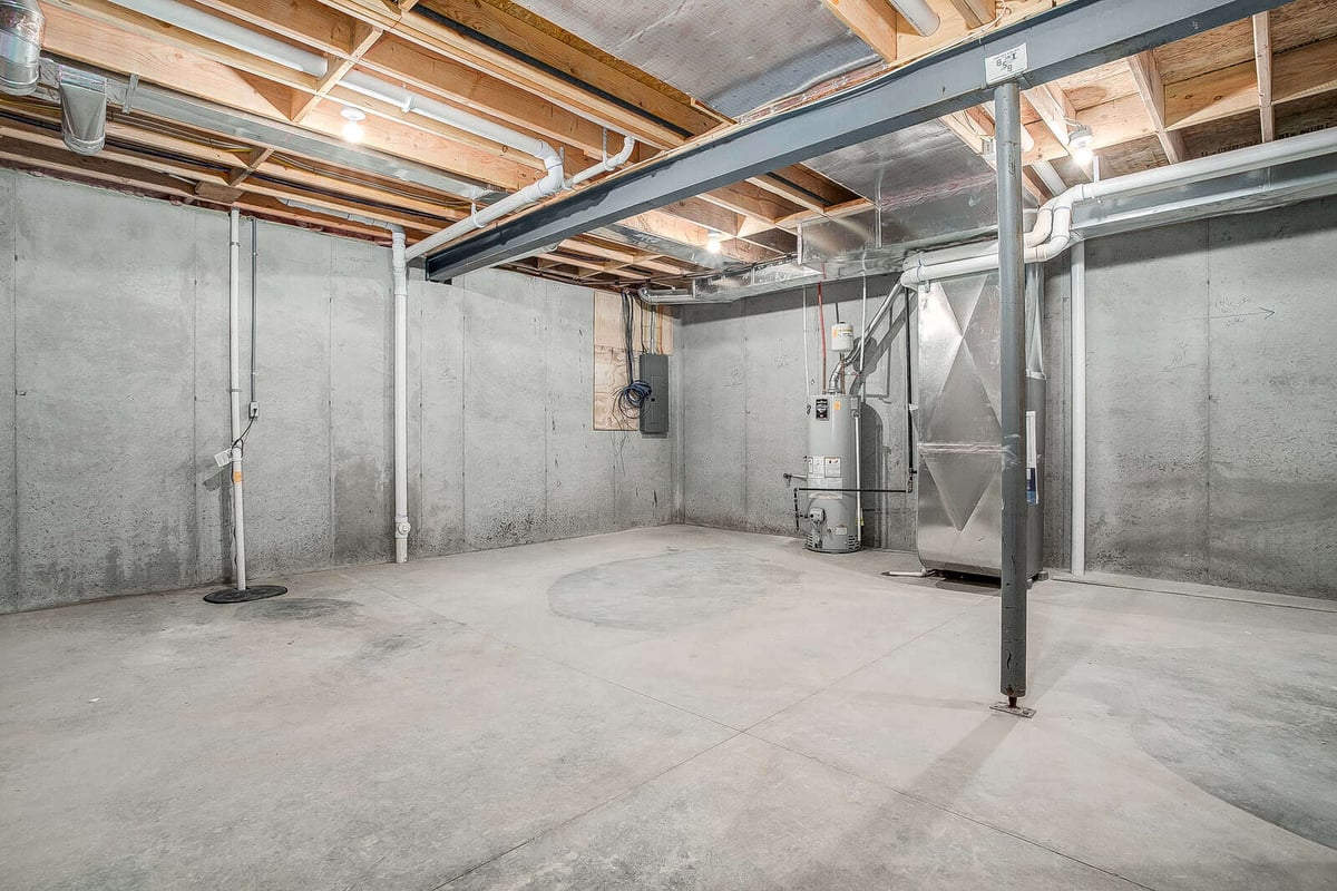 Unfinished basement space with exposed concrete and utilities, part of a Kansas City whole home remodel by Top Shelf Home Builders