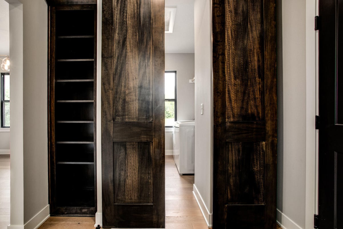 Custom-built hidden shelving space behind rustic barn doors, part of a Metro Kansas City home remodel