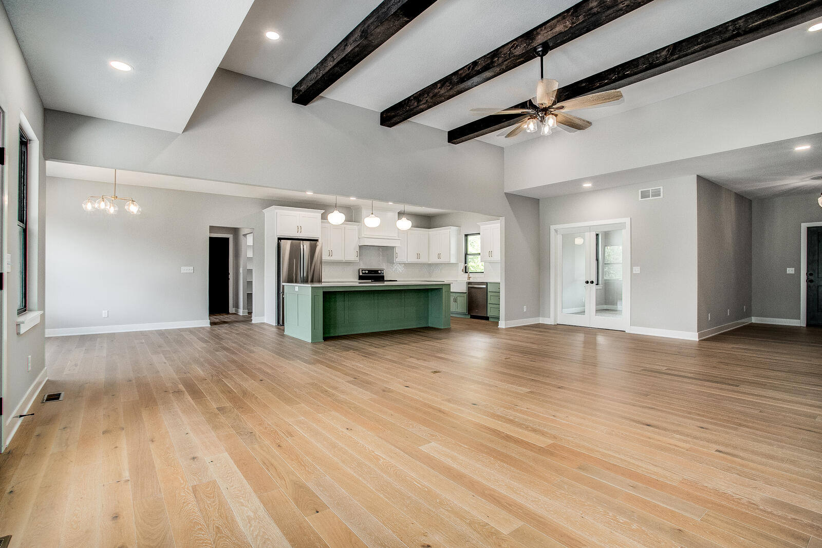Expansive open floor plan with high ceilings, a modern kitchen, and elegant finishes, part of a Kansas City home renovation