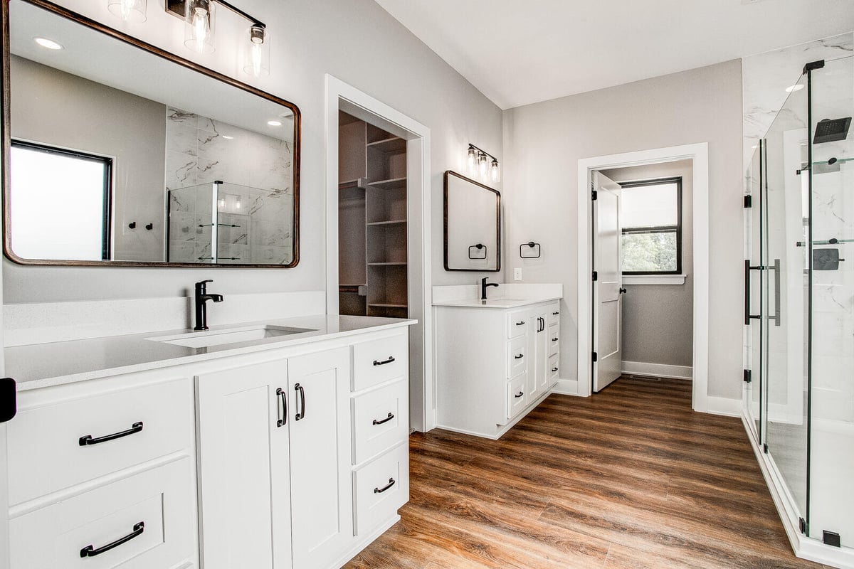 Luxurious master bathroom with dual vanities, quartz countertops, and modern black hardware, remodeled by Top Shelf Home Builders in Kansas City