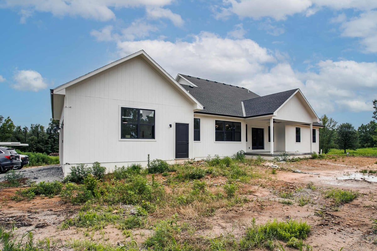 Newly constructed modern farmhouse with white board and batten siding and black windows by Top Shelf Home Builders in Metro Kansas City