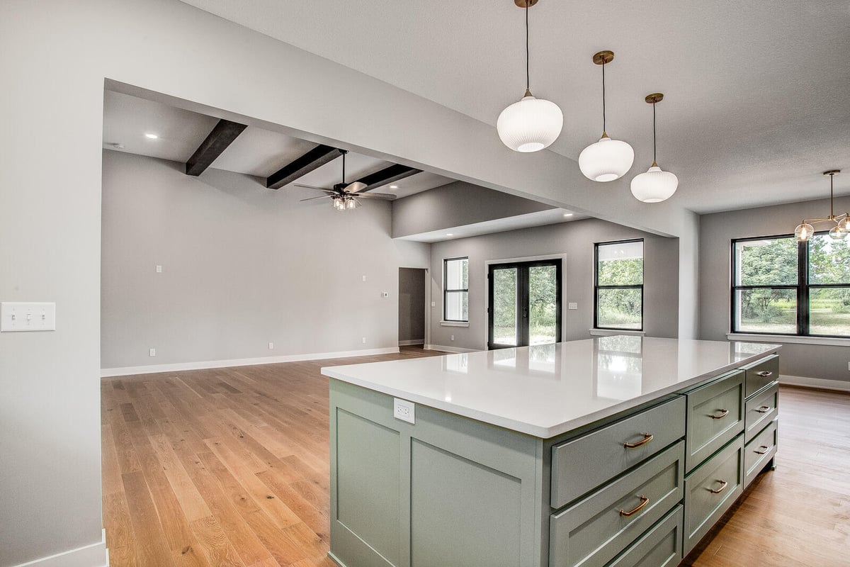 Open-concept kitchen and living area with a large island and pendant lighting, part of a whole home remodel by Top Shelf Home Builders in Metro Kansas City.jpg