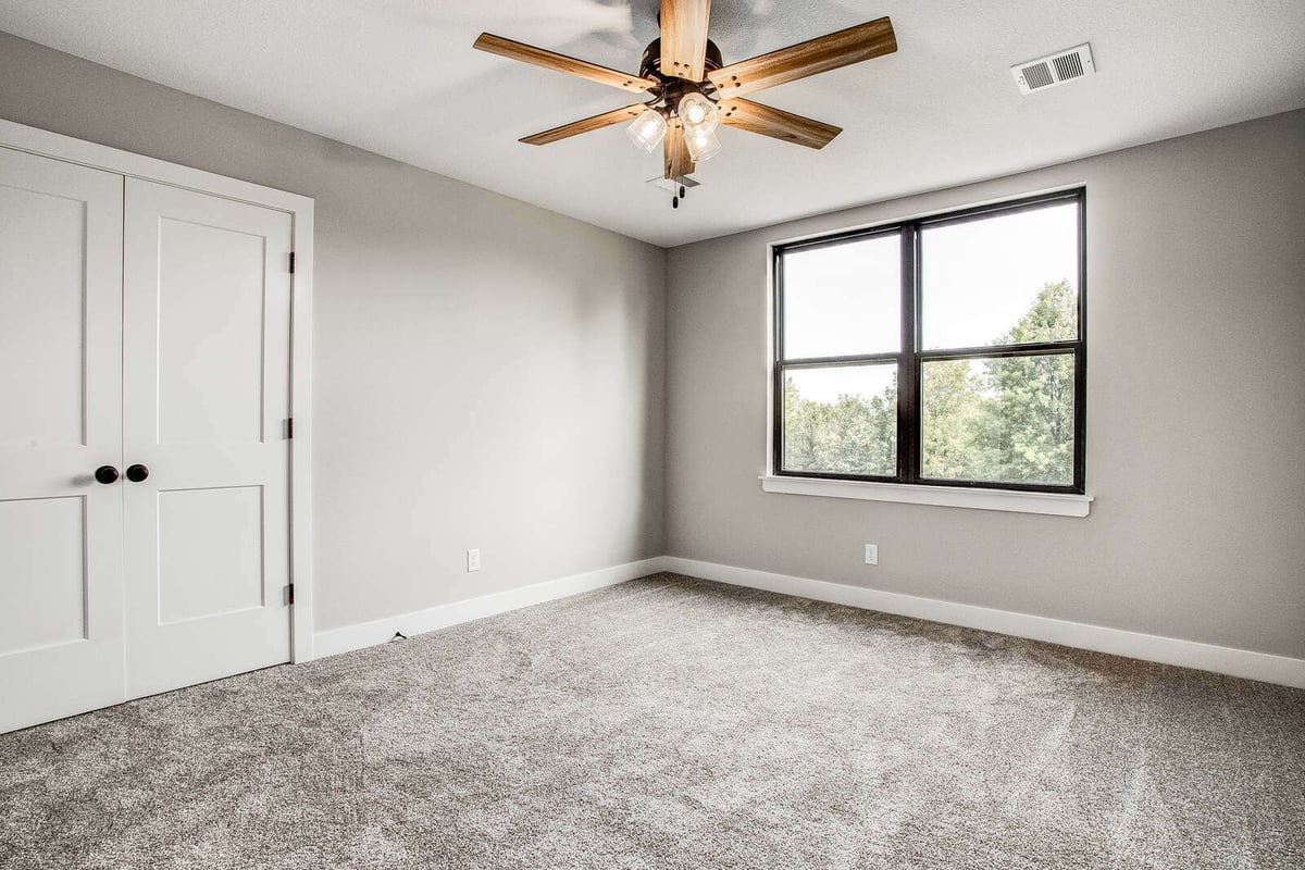 Renovated bedroom with large windows and neutral decor, part of a whole home remodel by Top Shelf Home Builders in Kansas City