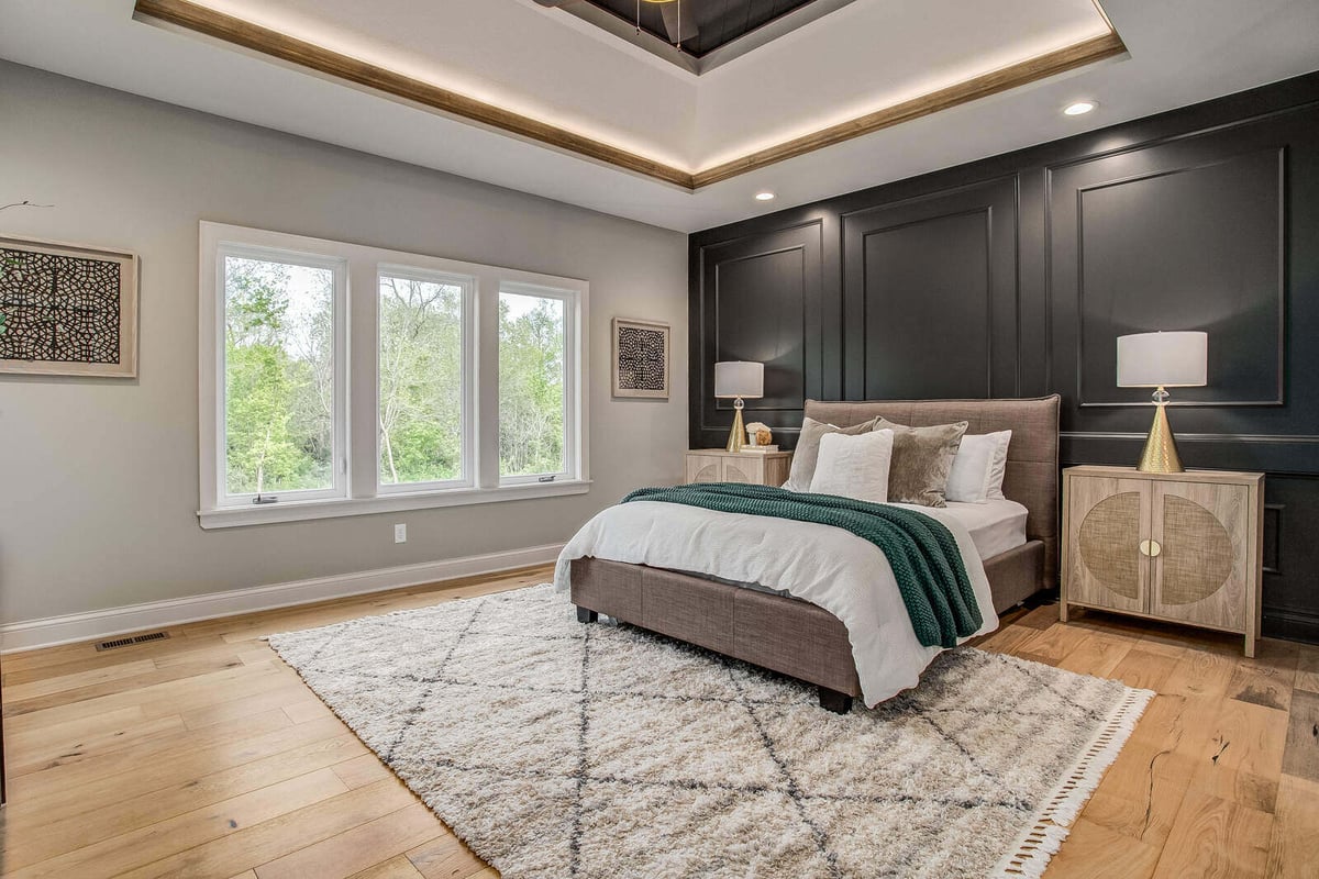 Elegant primary bedroom with black accent wall and tray ceiling in a Metro Kansas City home remodeled by Top Shelf Home Builders