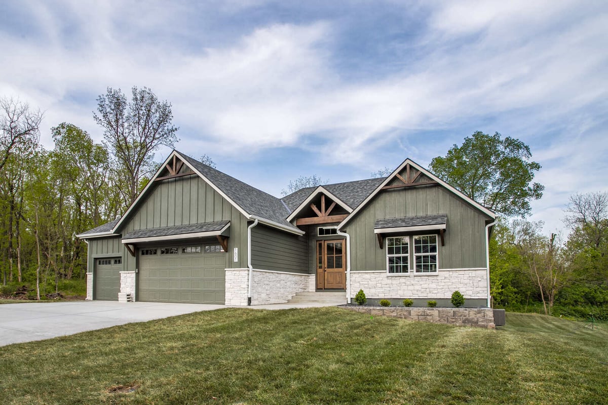 Rear view of a remodeled home with a covered deck and walk-out basement by Top Shelf Home Builders in Metro Kansas City