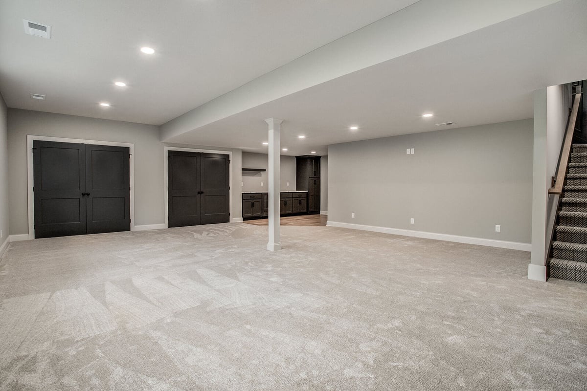 Spacious finished basement with an open floor plan, recessed lighting, and neutral tones in a Kansas City remodel