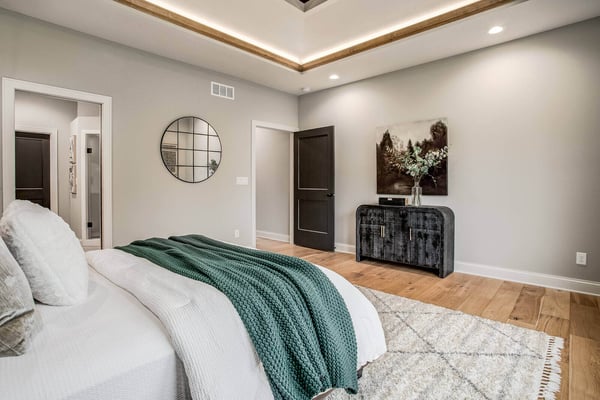 Spacious master bedroom with neutral tones and a modern ceiling design in a Metro Kansas City home remodel by Top Shelf Home Builders