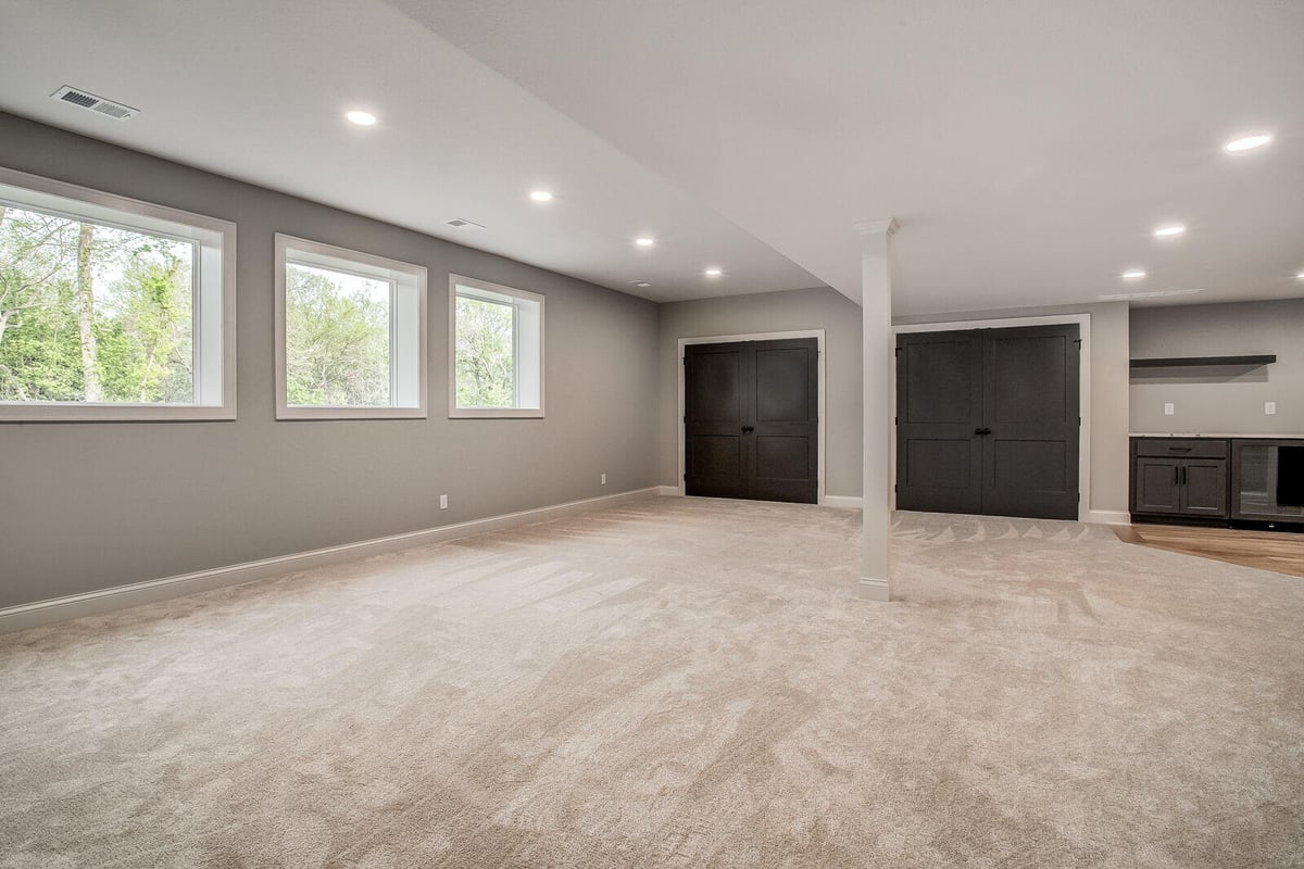 Stylish basement wet bar with black cabinetry and white countertops in a Metro Kansas City home remodel